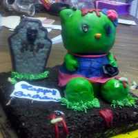 Zombie Hello Kitty this is a zombie hello kitty on a red velvet cake with buttercream frosting them with crushed oreos for dirt the hello kitty was pound cake...