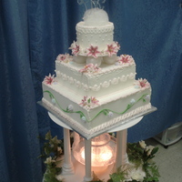 Final Project For Master Course At Wilton. Three tier wedding cake covered in royal icing and royal icing piping. Cake topper is and isomalt nest and isomalt monograms. Top tier has...