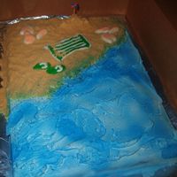 Beach_Cake2.jpg Half sheet, cherry chip cake with faux fondant icing. Golden oreos for sand and blue spray for the water. White and peach colored chocolate...