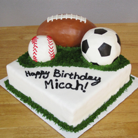 Sports Themed Cake The balls are made of rice treats and covered in fondant. Grass is buttercream icing. I desperately need to work on my penmanship on cakes...