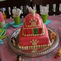 Pretty Little Puppies Three sqaure tiered cake covered in pink fondant and bright colored fondant stripes with doggie paw prints and cute little gumpaste puppy...