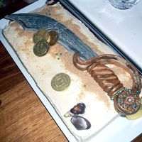Pirate Sword Cake Buttercake with vanilla buttercream icing. The sword is carved fondant decorated with edible silver & gold paint and cachous. Edible...