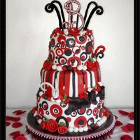Black And Red Whimsy Circles The cakes are covered in fondx. The B top is gumpaste with gumpaste pearls and silver dagrees. The rest of the decorations are fondant.