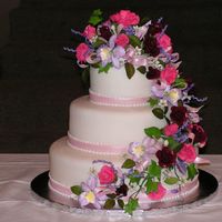 Fondant And Gumpaste Wedding Cake Fondant covered cake with handmade gumpaste flowers, greenery, ribbon, etc.