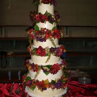 Sara.jpg This wedding cake was assembled using the tall tier stand and silk flowers provided by the bride. The layers were sizes 6-16 in two inch...