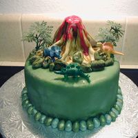 Dino Cake I made this cake for my son's birthday. The dinos are the only thing that are not edible. I put luster dust on them as well as on the...