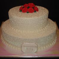 Bridal Shower Cake Two-tier buttercream iced bridal shower cake with cornelli lace design on tops and sides of tiers. Royal icing roses and fondant plaque.