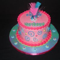 Whimsical Birthday Cake Buttercream iced cake with fondant and dragee accents; whimsical feather topper.