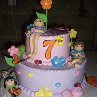 Fairies And Flowers Birthday cake for 7 year old girl that loves fairies. Cake is covered in buttercream. Fairies and flowers made from fondant.