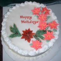 Painted Poisettias Royal frosting shaped poinsettias set on a fondant plaque with painted poinsettias and pine branches.