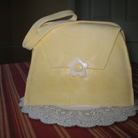 Purse Cake The cake is just an 8" square cake that I cut in thirds, then stacked. Then I just shaped it by hand with a serrated knife. Iced in...