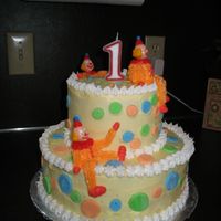 Two Tier Stacked Clown Cake I made this cake for my daughter's first birthday. The icing, clowns and borders are buttercream and the polka-dots are mmf.