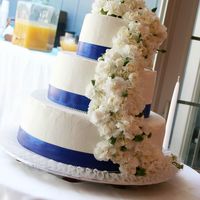 Ben And Edna Wedding Cake Buttercream frosting, blue ribbon, pearls and Carnations. Cake is a white with rasberry filling and a lemon with raspberry filling.