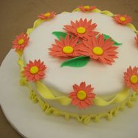 Orange Daisies This was my first fondant/gumpaste cake. I used mmf for the coverage and the flowers/borders are gumpaste.