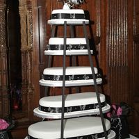 Butterfly Black And White Wedding Cake 5 tier fruit cake covered with fondant. It has black ribbon aroung the base of each cake and small butterlies attached around the ribbon....