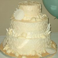 Beach-Theme Wedding Cake Buttercream icing. Sand dollars are made from gumpaste, shells are made from chocolate.