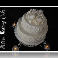 Wedding Cake Almond Buttercream with white cake with raspberry and white chocolate filling. Fondant Bow.