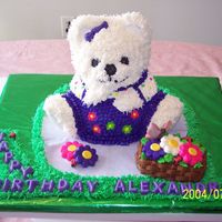 Bear Sitting On Fondant Blanket The bear's fur is made by using the grass tip. Candy flowers, fonant butterflies and lady bugs.