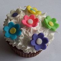 Mother's Day Cupcake This bright and flowery cupcake was designed for Mother's Day. Colored fondant flowers increamy vanilla icing.