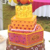 Colorful Dots Wedding Cake Warm colors and Dots in a variety of designs. All butter cream icing. The cake topper is artificial fruit to compliment the warm, bright...