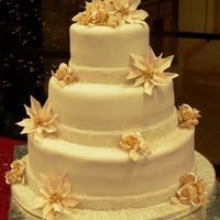 Christmas Wedding Cake Gumpaste roses & poinsettias, berries are dipping in piping gel & sanding sugar. Ribbon was painted with piping gel then sprinkled...