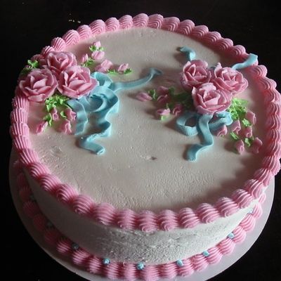 Round Cake With Blue Ribbons And Pink Flowers