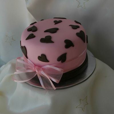 A 4 Inch Round Mud Cake Made Just To Practice. Covered In Pink Fondant With Chocolate Fondant Hearts And A Chocolate Fondant Strip Around...