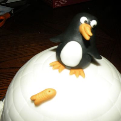 Penguin And Fish On Top Of The Igloo