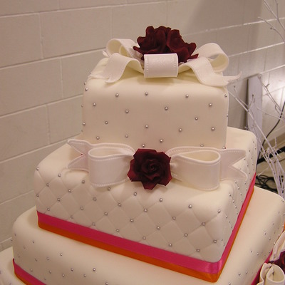 White Wedding Cake With Bows And Red Roses