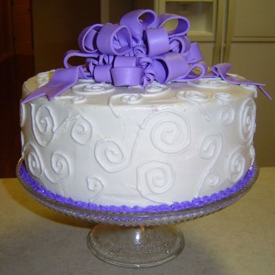 White Cake With Swirls And Purple Bow