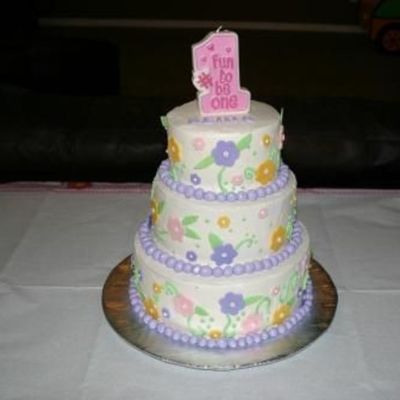 Buttercream With Fondant Flowers And Border With Candle On Top