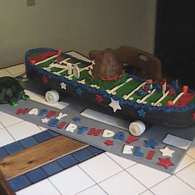 Skateboard With Football Field On The Road By A Passing Turtle