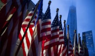 One World Trade Center is seen behind U.S flags on the morning of the 14th anniversary of the 9/11 attacks, in Lower Manhattan i