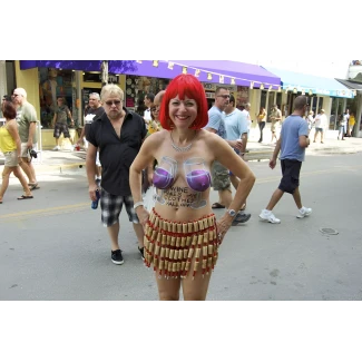 Almost nude mature lady in body paint and a skirt made of corks revealing her boobs and displaying her pussy