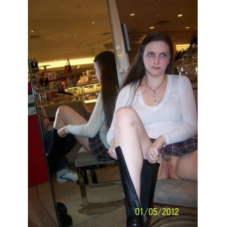 Trying on a shoe inside a shop in a short skirt and showing her pussy