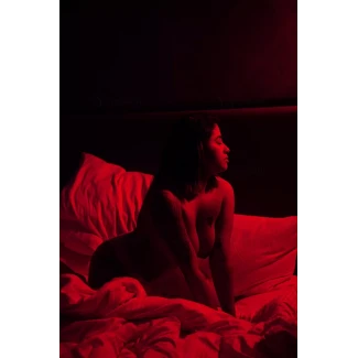 Mature Indian hottie kneeling and squeezing her boobs and posing naked as a jaybird on bed in redlight