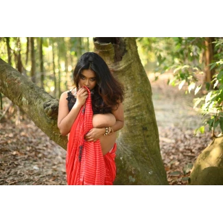 Ishani Das with big heavy tits revealing one large breast in a striped saree stands exhibitionist in a dense forest