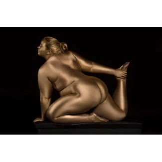 BBW model with large pendulous breasts and visible ass in golden body paint kneels on black surface