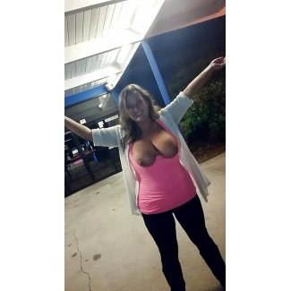 Showing her big tits and posing almost topless outside an ATM