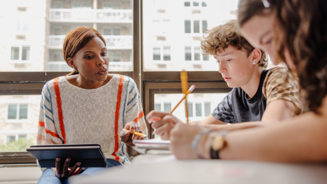 Teacher with tablet working with students hero WF2402150