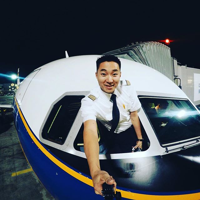 A smiling pilot poses in the cockpit of an airplane, capturing a moment of aviation pride and professional fulfillment.