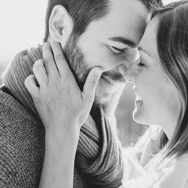 An intimate black and white portrait of a loving couple, showcasing connection and affection in a minimalist style.