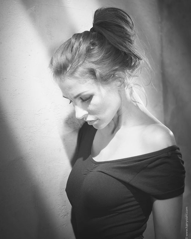 Black and white portrait of a woman in soft light, showcasing a sensual and intimate atmosphere.