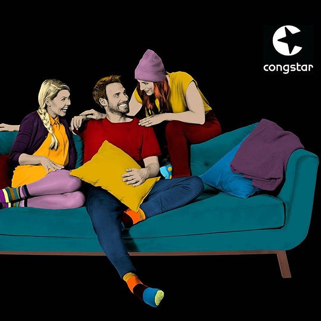 Three friends hang out on a couch, laughing and enjoying each other's company in a colorful setting.