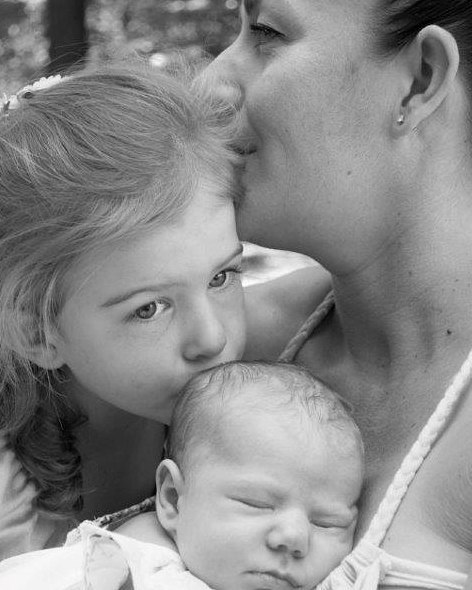A tender moment captured in black and white of a mother and her daughters.