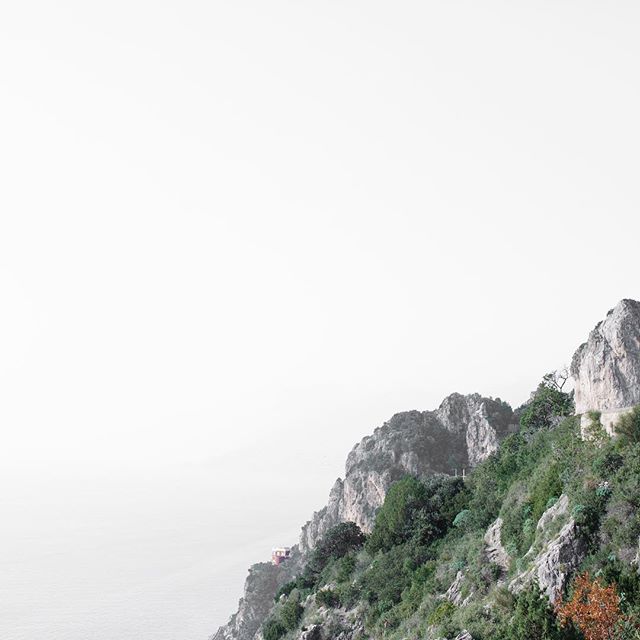 Coastal mountains covered in lush greenery meet the sea in a serene landscape, ideal for nature lovers.