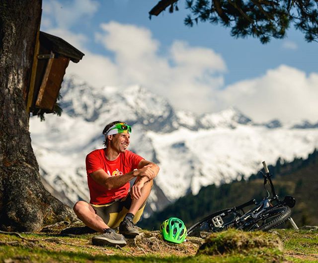 A mountain biker relaxes by his bike in the mountains, enjoying nature.