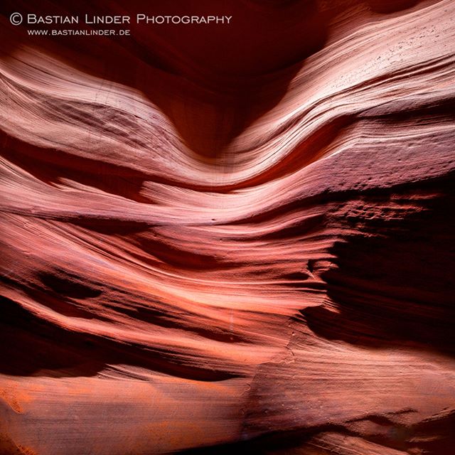 Abstract view of smooth sandstone walls in a slot canyon, showcasing warm, earthy tones and natural textures.