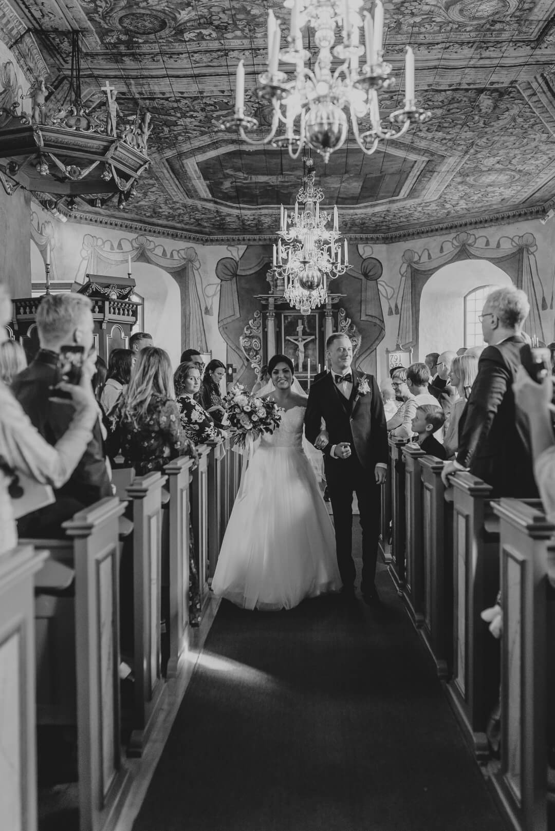 A bride and her father walk down the aisle during a classic church wedding ceremony.