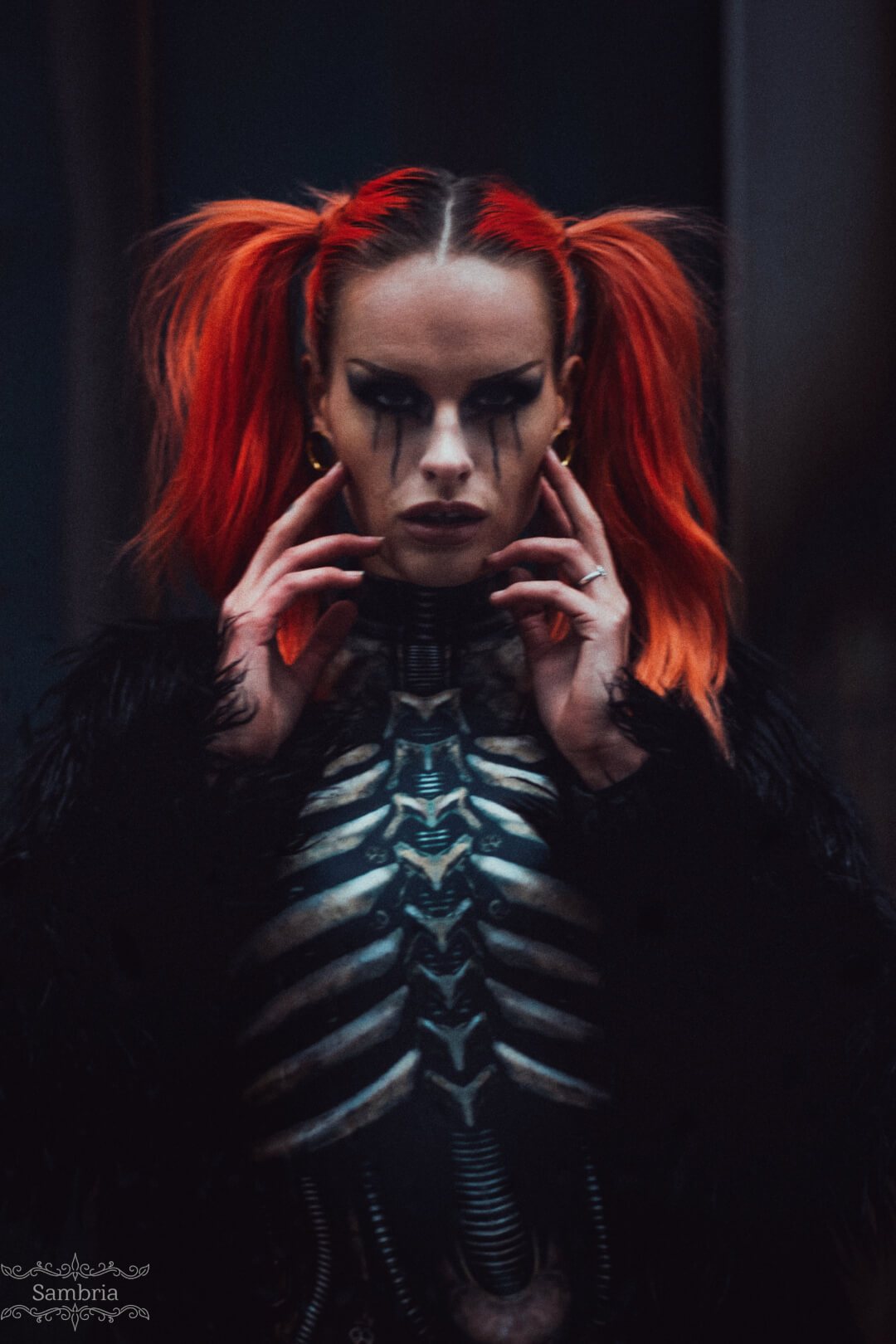 A woman with red hair and skeleton makeup poses for an intense editorial portrait.